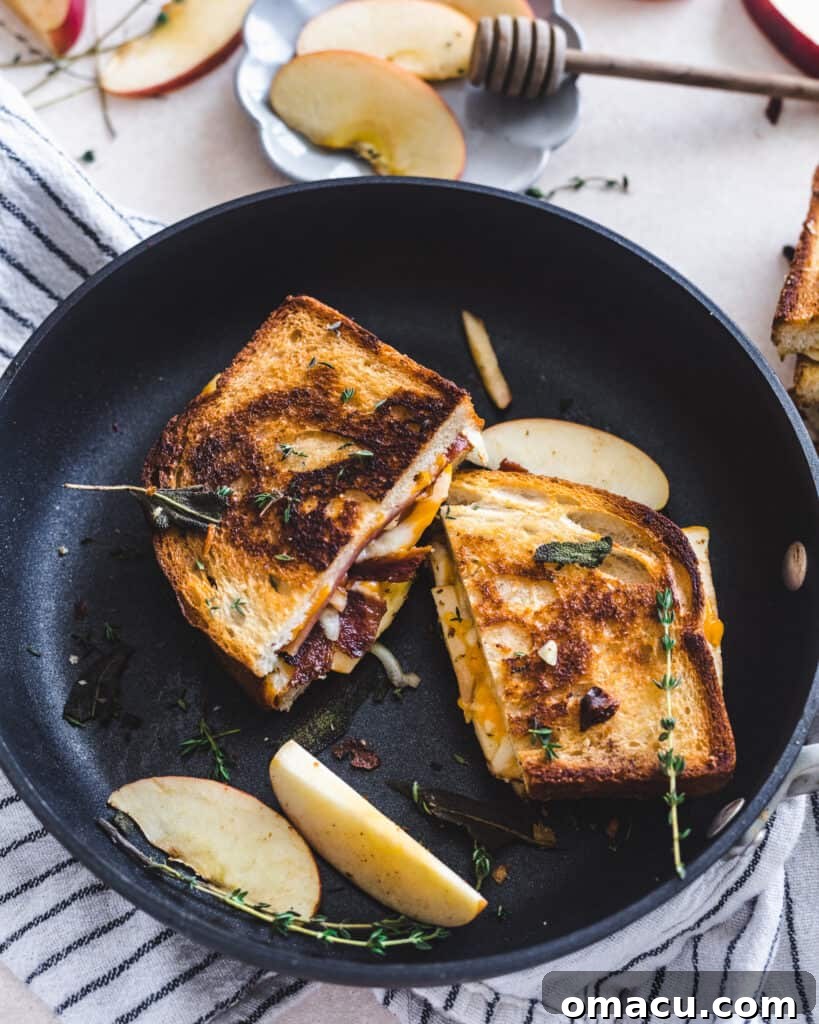 Another view of the Apple Bacon Cheddar Grilled Cheese, halved and stacked, highlighting its golden crust and melted interior.