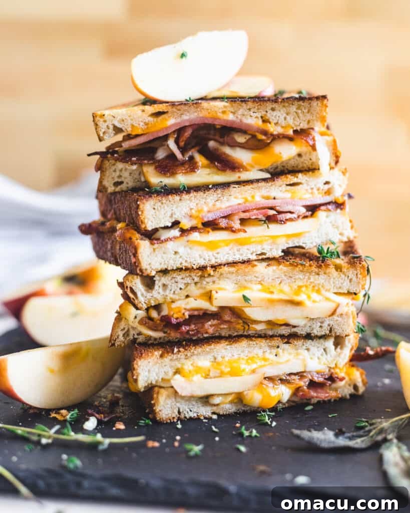 Up-close shot of a deliciously melted Apple Bacon Cheddar Grilled Cheese sandwich.
