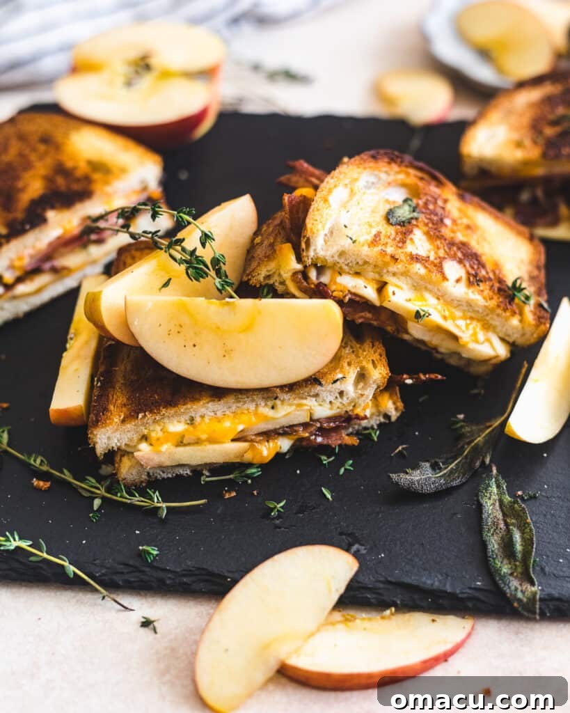 Crispy Apple Bacon Cheddar Grilled Cheese halves, showing off the perfectly melted cheese.