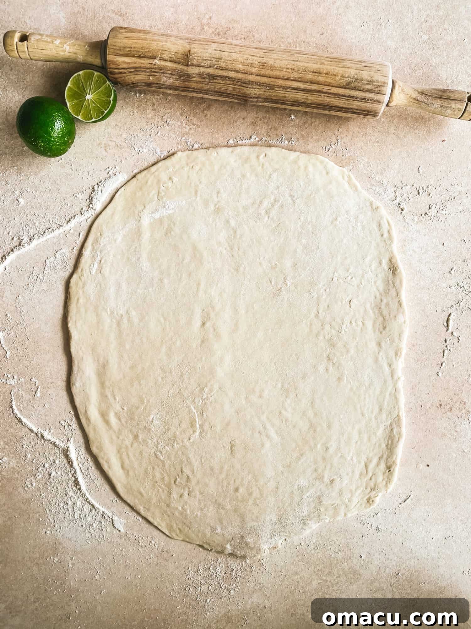 Puff pastry dough being rolled into a rectangle on a floured surface, a key step in making homemade puff pastry.