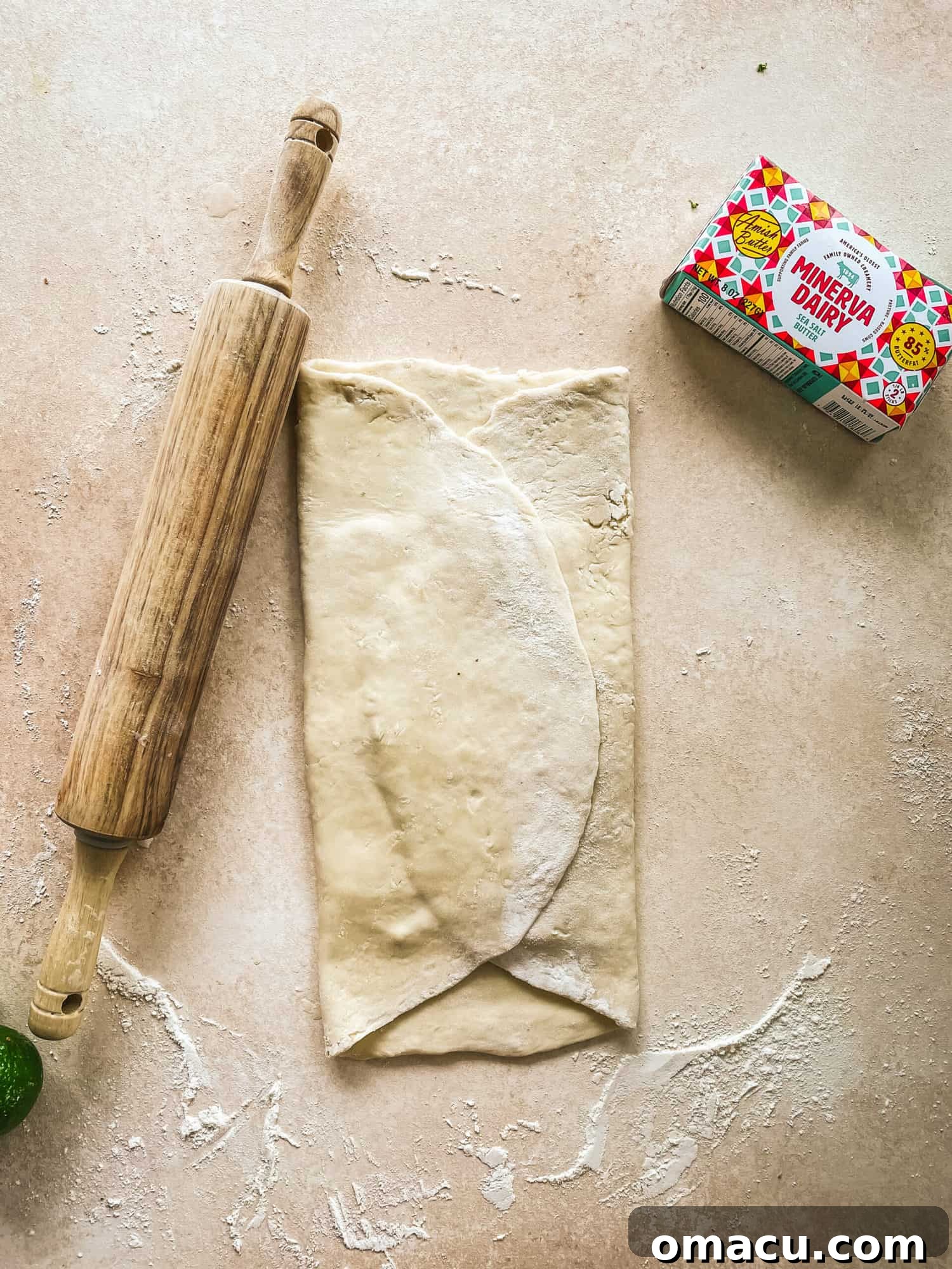 Puff pastry dough folded over a butter block, forming an envelope shape to begin the layering process.