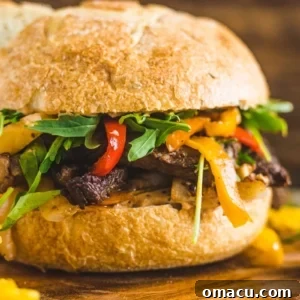 steak sandwich on a cutting board with chips and pickles