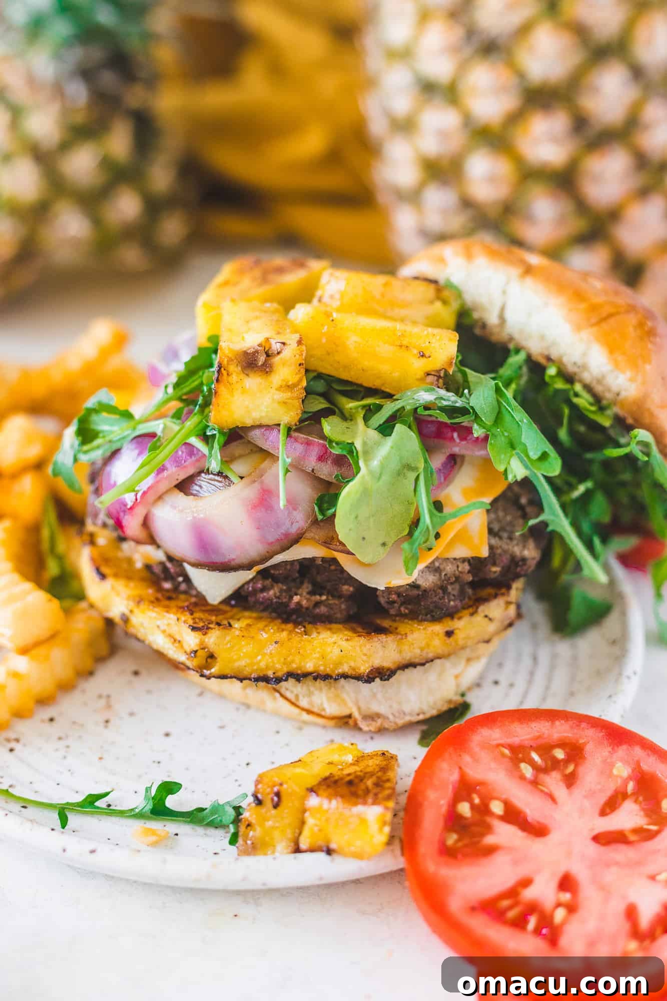 Close-up shot of a Jamaican Jerk Burger on a plate, highlighting the perfectly grilled patty, caramelized pineapples, and fresh arugula, accompanied by golden fries.
