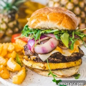 burger and fries on a plate with pineapples in the background