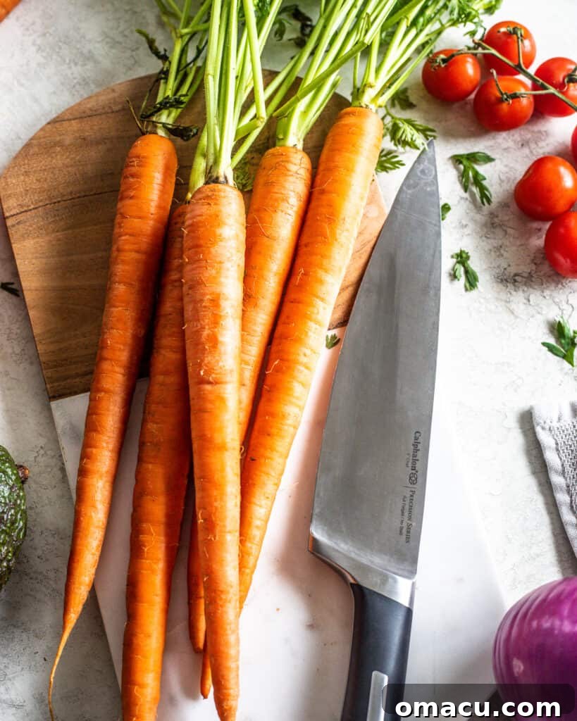 Freshly julienned carrots neatly piled on a wooden cutting board