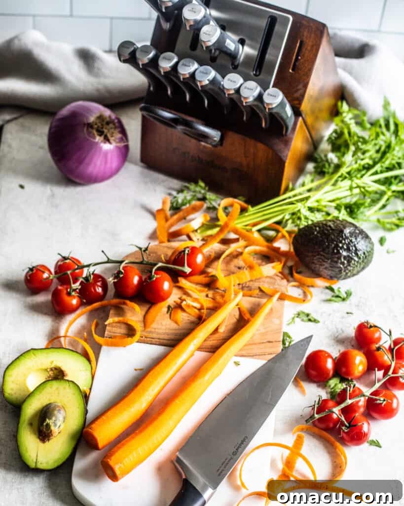 A carrot being peeled with a potato peeler on a cutting board