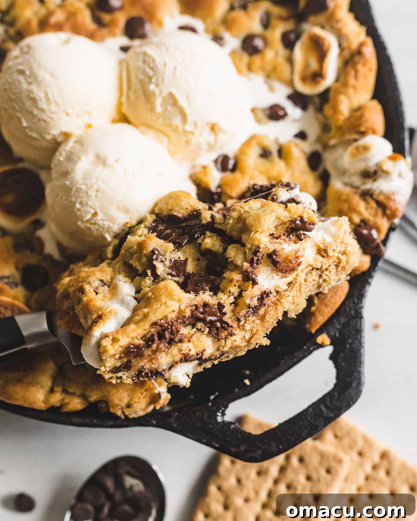 Close-up of the molten, gooey center of the S'mores Stuffed Chocolate Chip Skillet Cookie, with chocolate and marshmallow melting together.