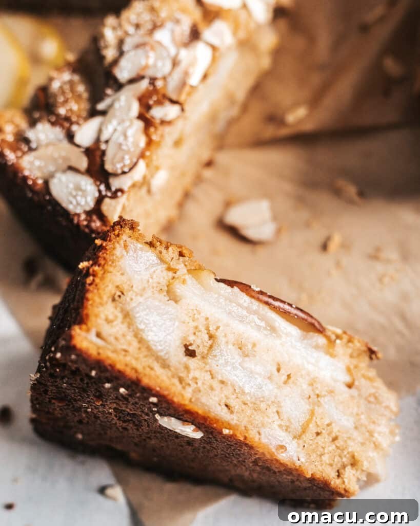 A generous slice of Spiced Pear and Almond Cake on a plate, highlighting its delicious layers and moist crumb.