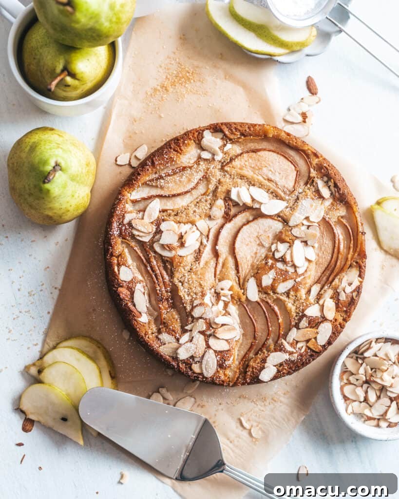 The Spiced Pear and Almond Cake beautifully arranged with fresh pears on a white background, suggesting a delightful culinary experience.