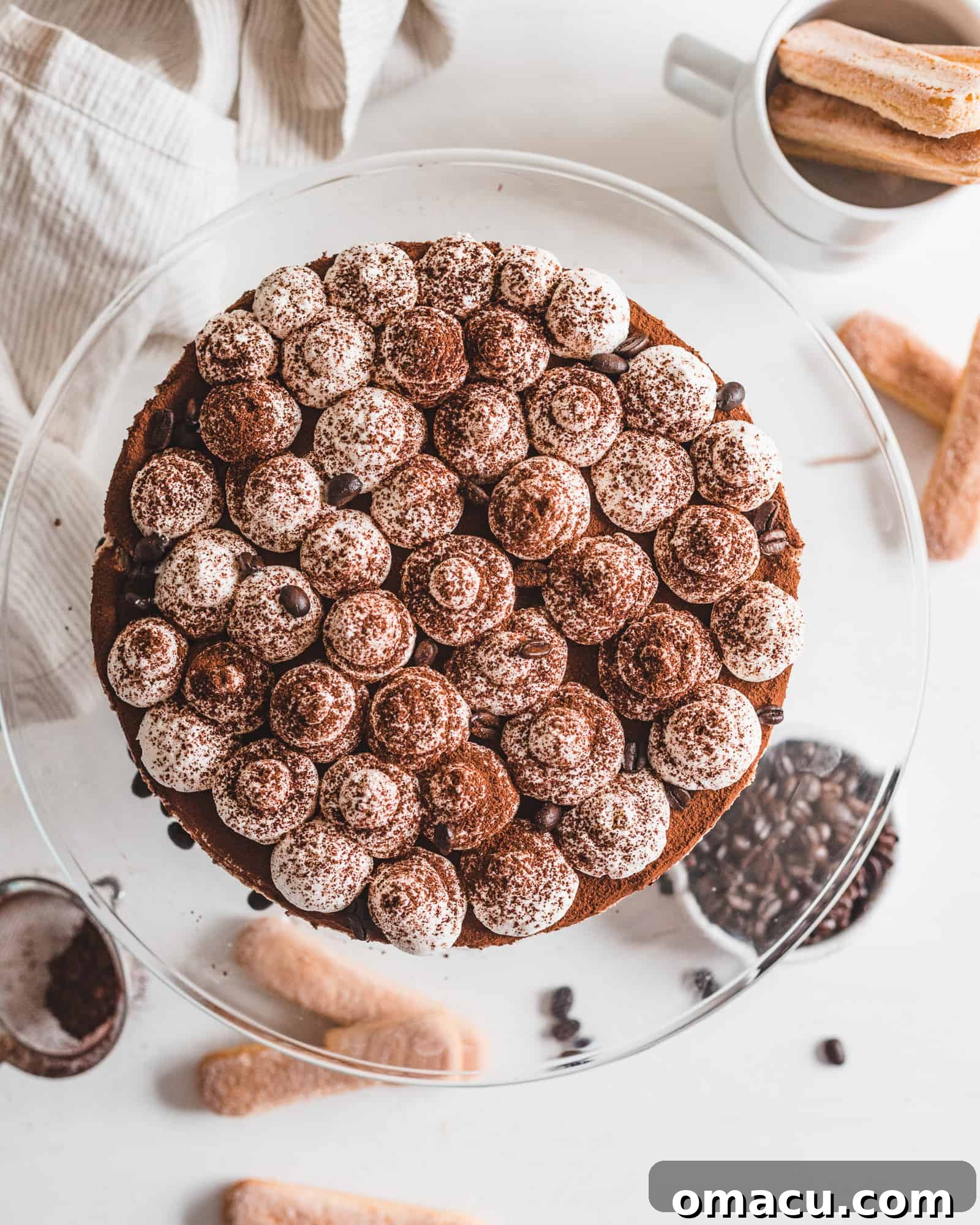 A perfectly prepared No-Bake Tiramisu Cheesecake, beautifully presented on a cake stand, ready to be served and enjoyed.