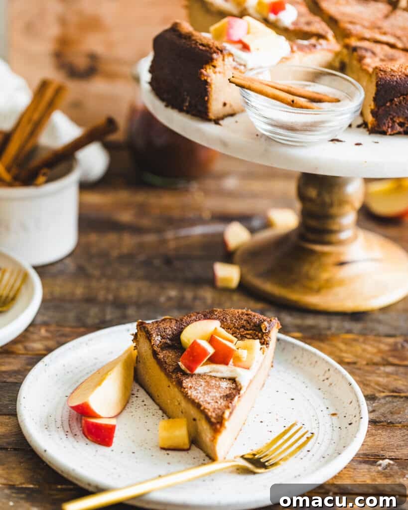 A generous slice of Apple Butter Basque Cheesecake beautifully plated, with the rest of the cheesecake visible in the background, inviting guests to savor its unique appeal.