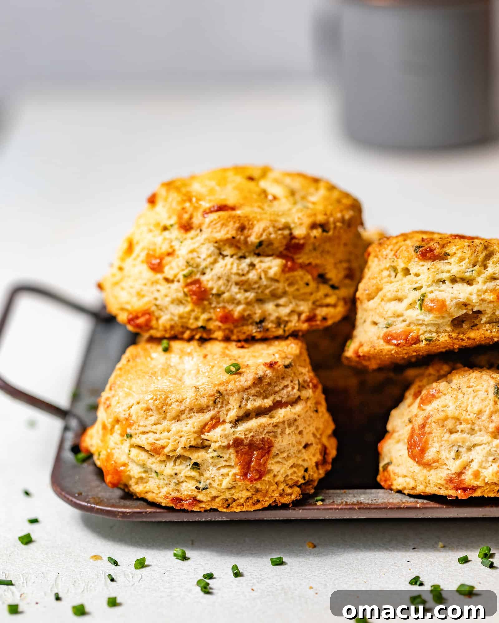 cheddar biscuits on a silver platter stacked up on top of each other.