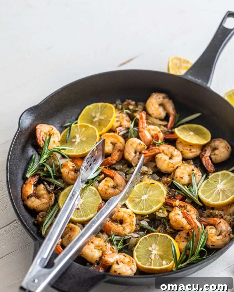 Shrimp in a cast iron skillet with lemons and herbs
