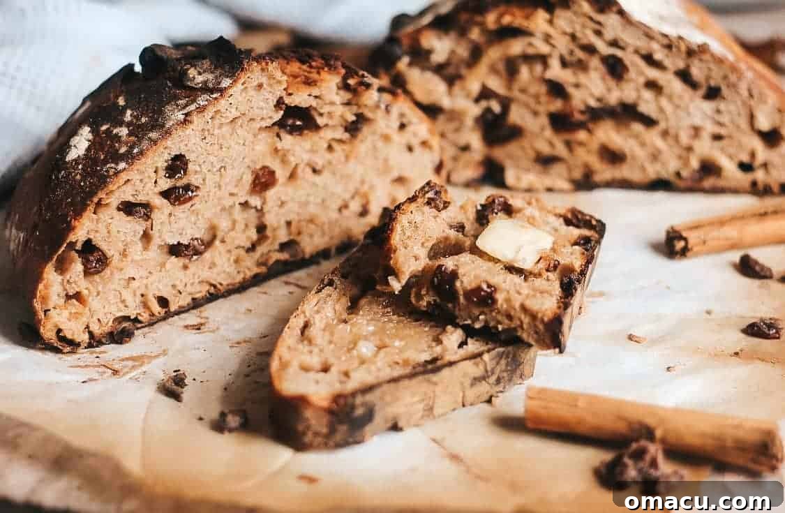 A perfectly baked loaf of cinnamon raisin sourdough bread on a rustic wooden board, ready to be sliced.