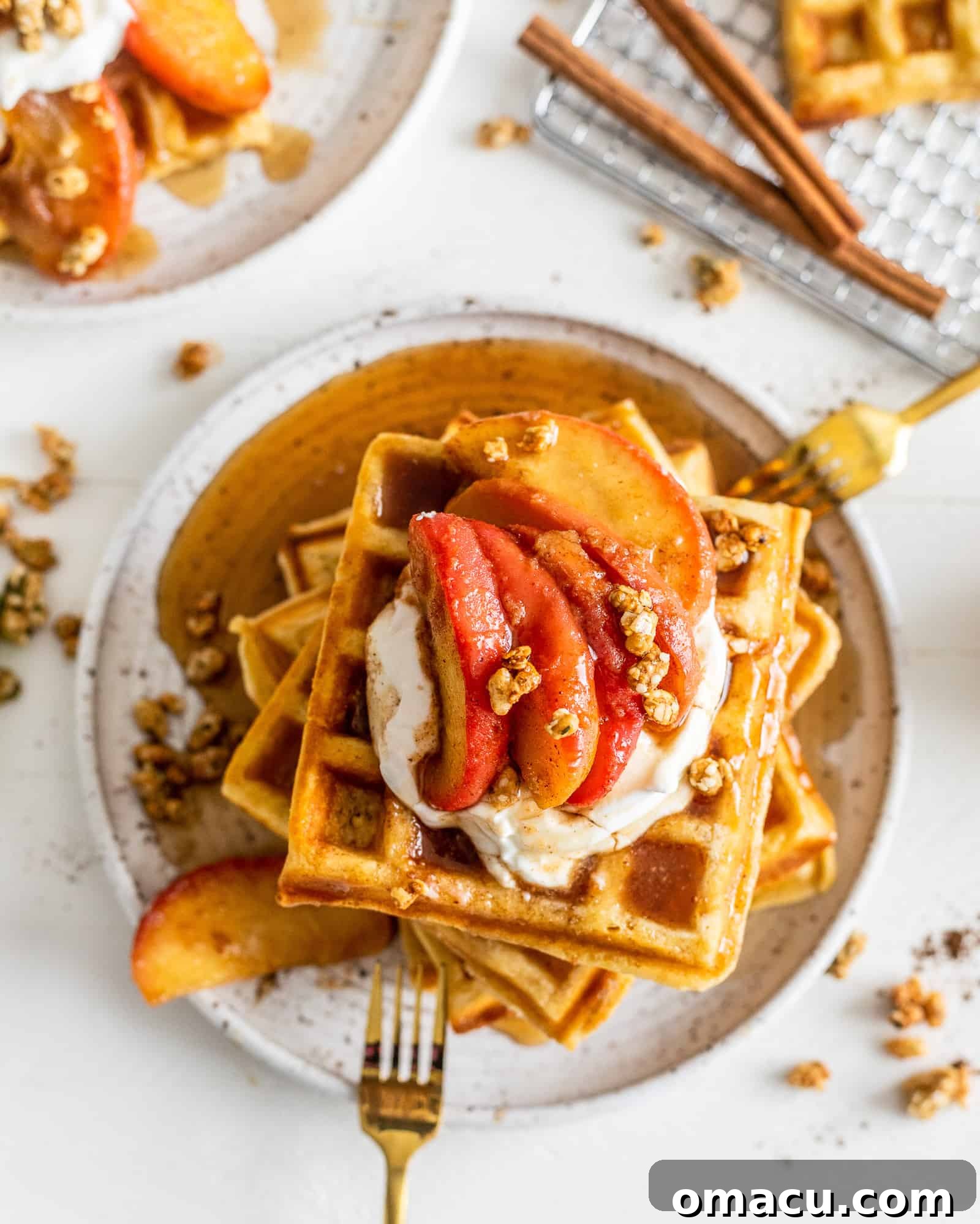 Overhead view of waffles drizzled with syrup and cinnamon apples
