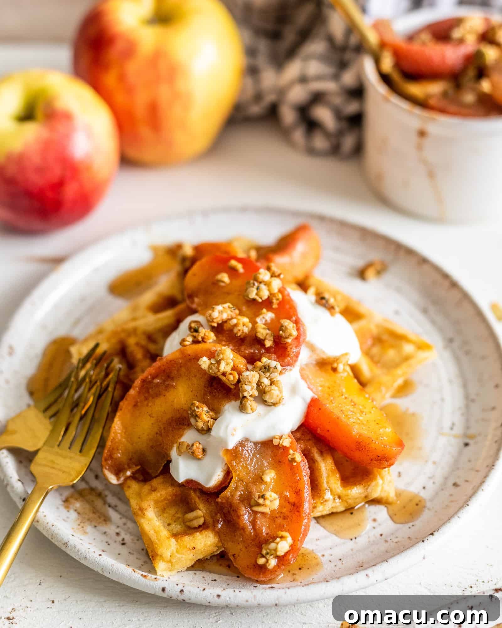 Close-up of brown butter waffles with cinnamon apples on a white plate