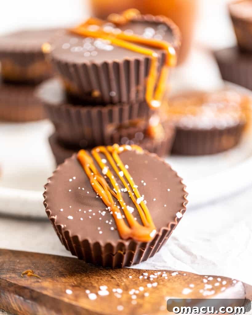 A close-up view of freshly made salted caramel peanut butter cups, artfully drizzled with golden caramel and ready to be enjoyed.
