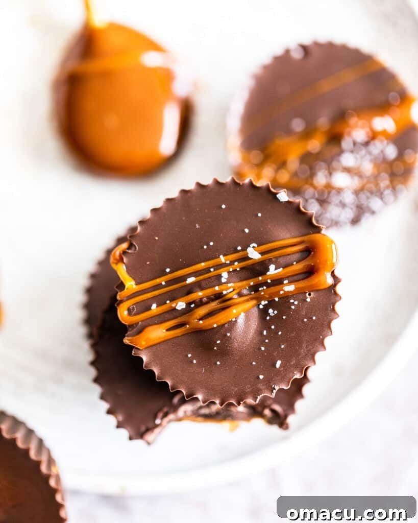 An overhead view of luscious, golden caramel being expertly drizzled over a batch of homemade peanut butter cups.