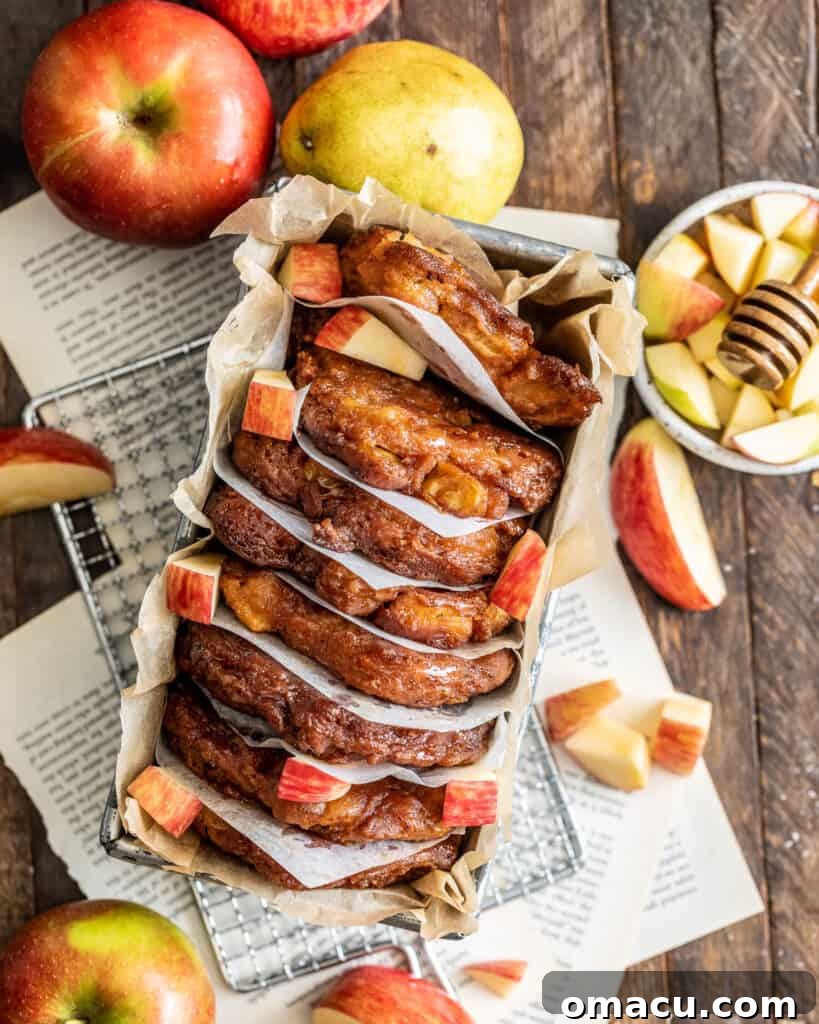 Apple Pear Fritters with Honey Glaze in a Loaf Pan surrounded by fresh apples and a pear