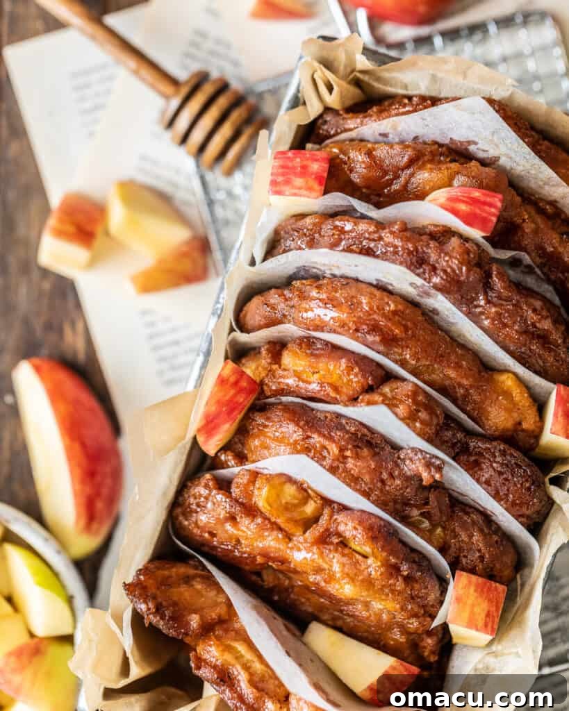 Overhead photo of a loaf pan filled with apple pear fritters, glistening with honey glaze.