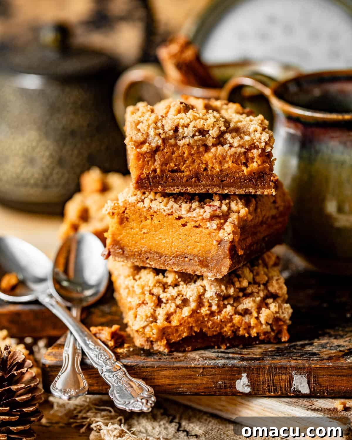 Stacked sweet potato pie bars on a wooden board, showcasing their layers and inviting texture.