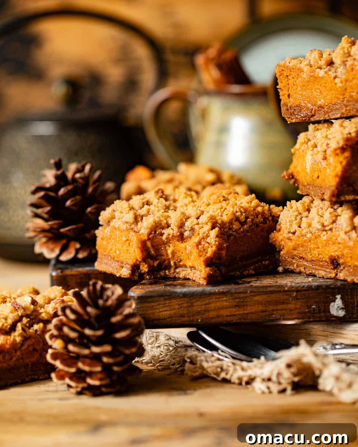 A single sweet potato pie bar on a cutting board with a bite taken, revealing the smooth filling and crumbly crust.