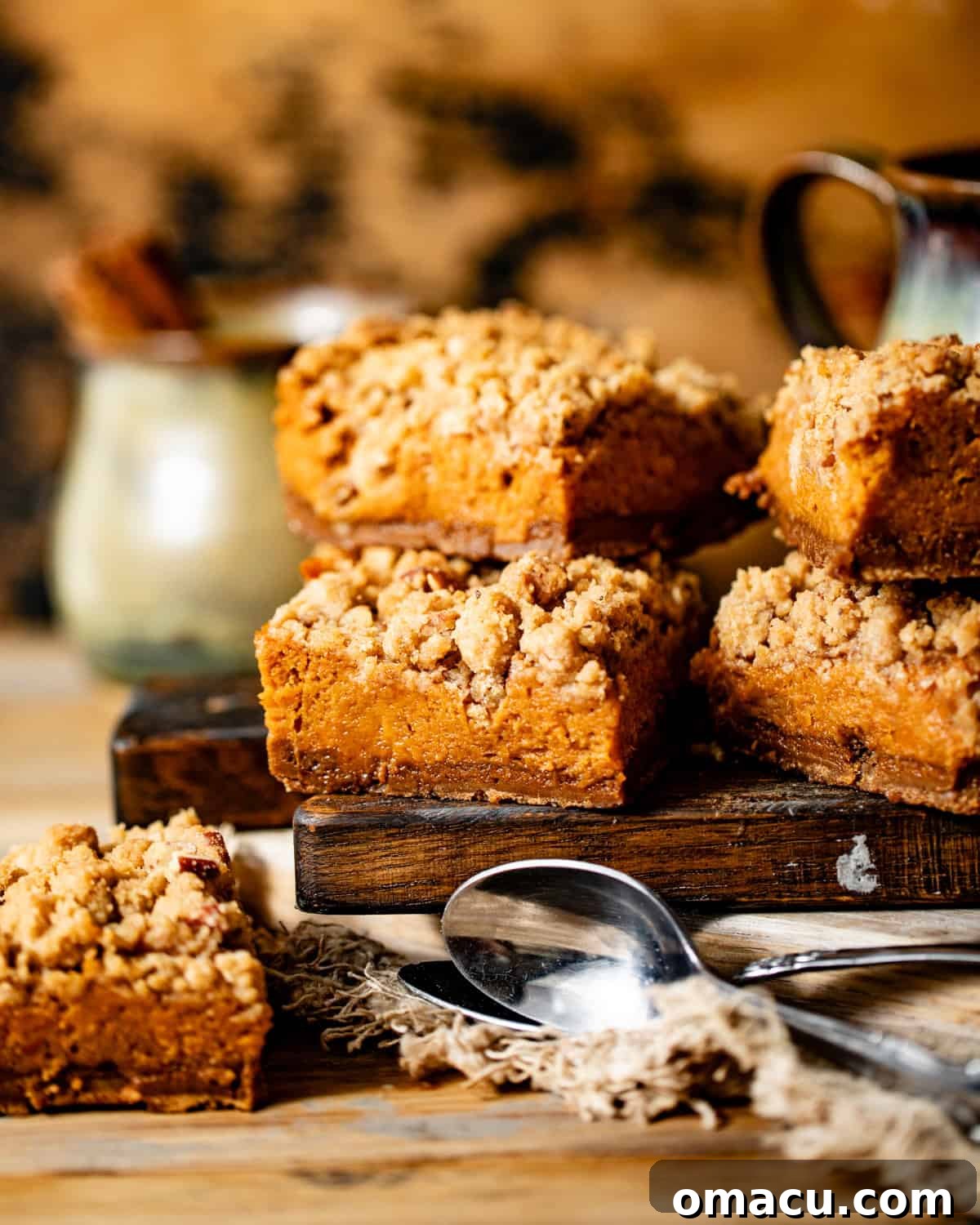 Perfectly cut sweet potato pie bars arranged on a wooden board with small spoons, ready to be served.
