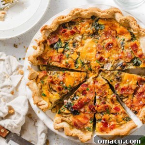 bacon mushroom spinach quiche in a pie dish with fresh herbs and lemons in a bowl next to it.
