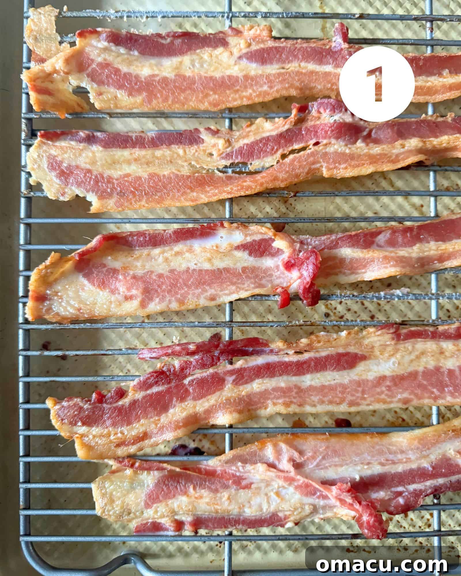 Crispy strips of cooked bacon resting on a wire rack, allowing excess grease to drain, ready to be chopped for the quiche filling.