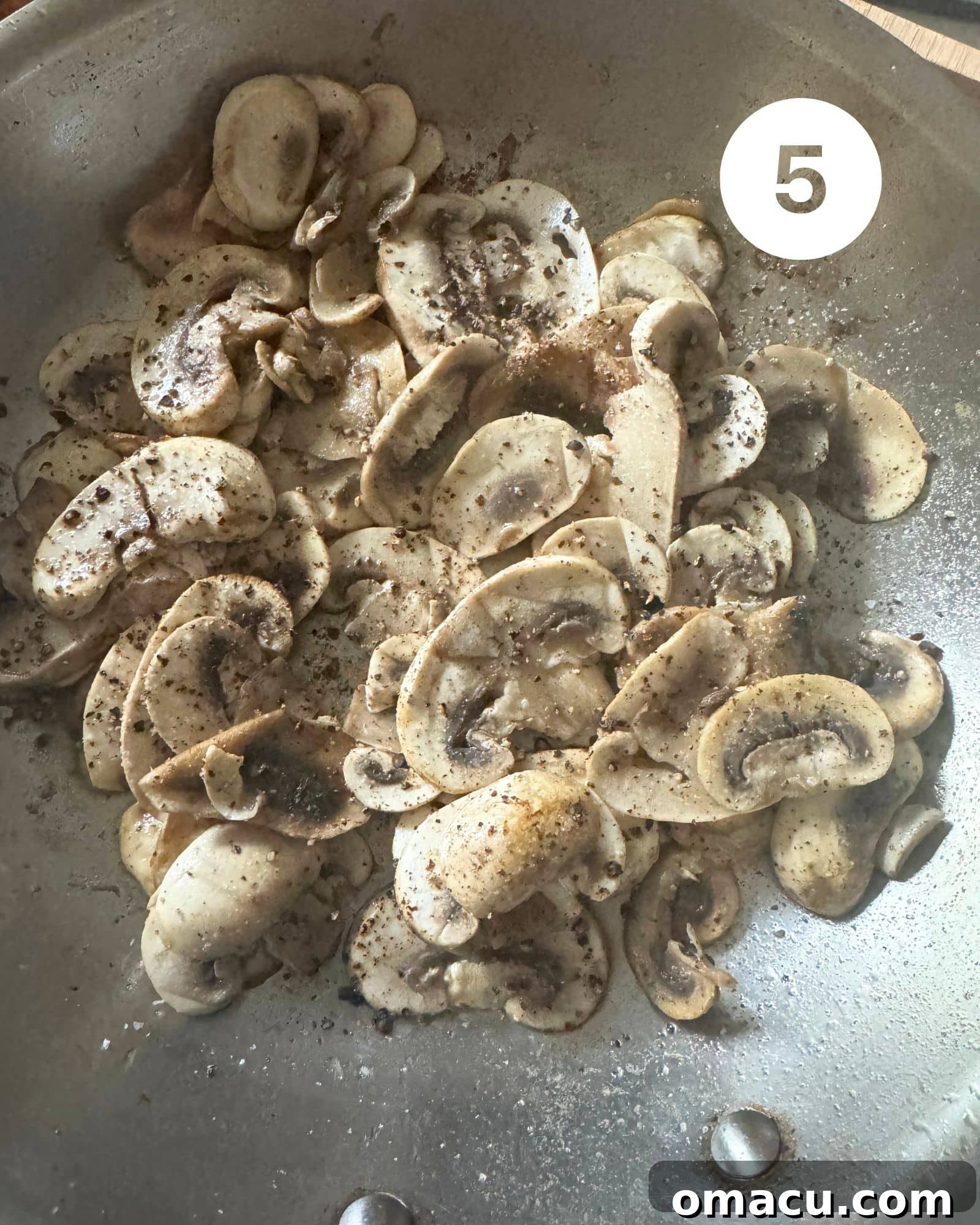 Freshly sautéed mushrooms, perfectly browned and tender, in a large skillet, ready to be added to the quiche filling.