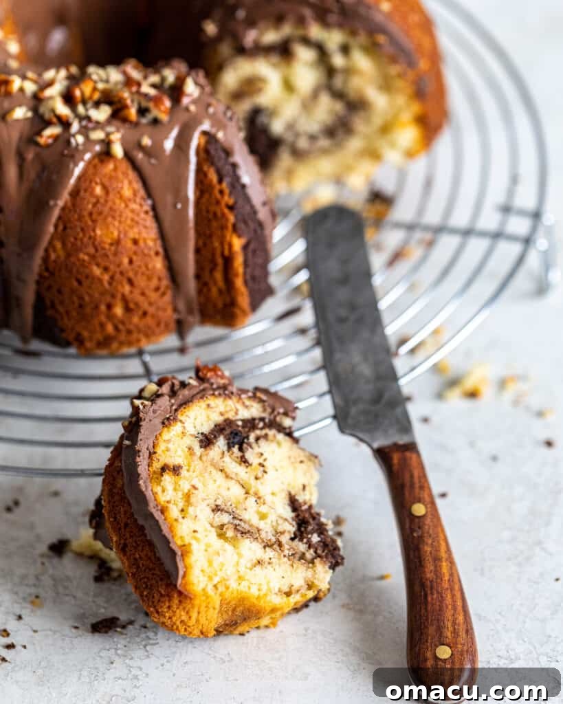 A close-up photograph of a beautifully plated slice of chocolate coffee marble cake, showing off its perfectly baked texture and rich glaze.
