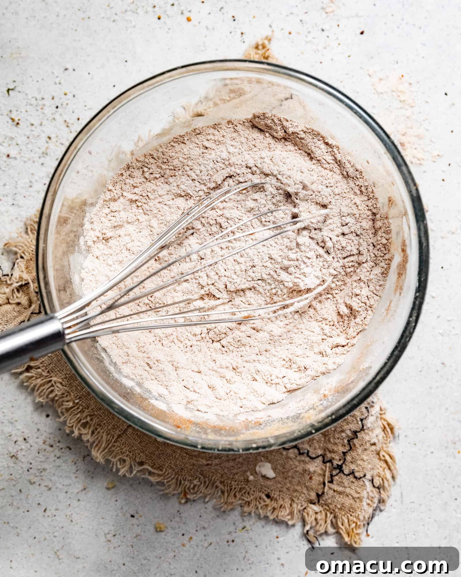 The dry ingredients for the Dutch Apple Cake, including flour, spices, and leavening agents, perfectly mixed in a large bowl.