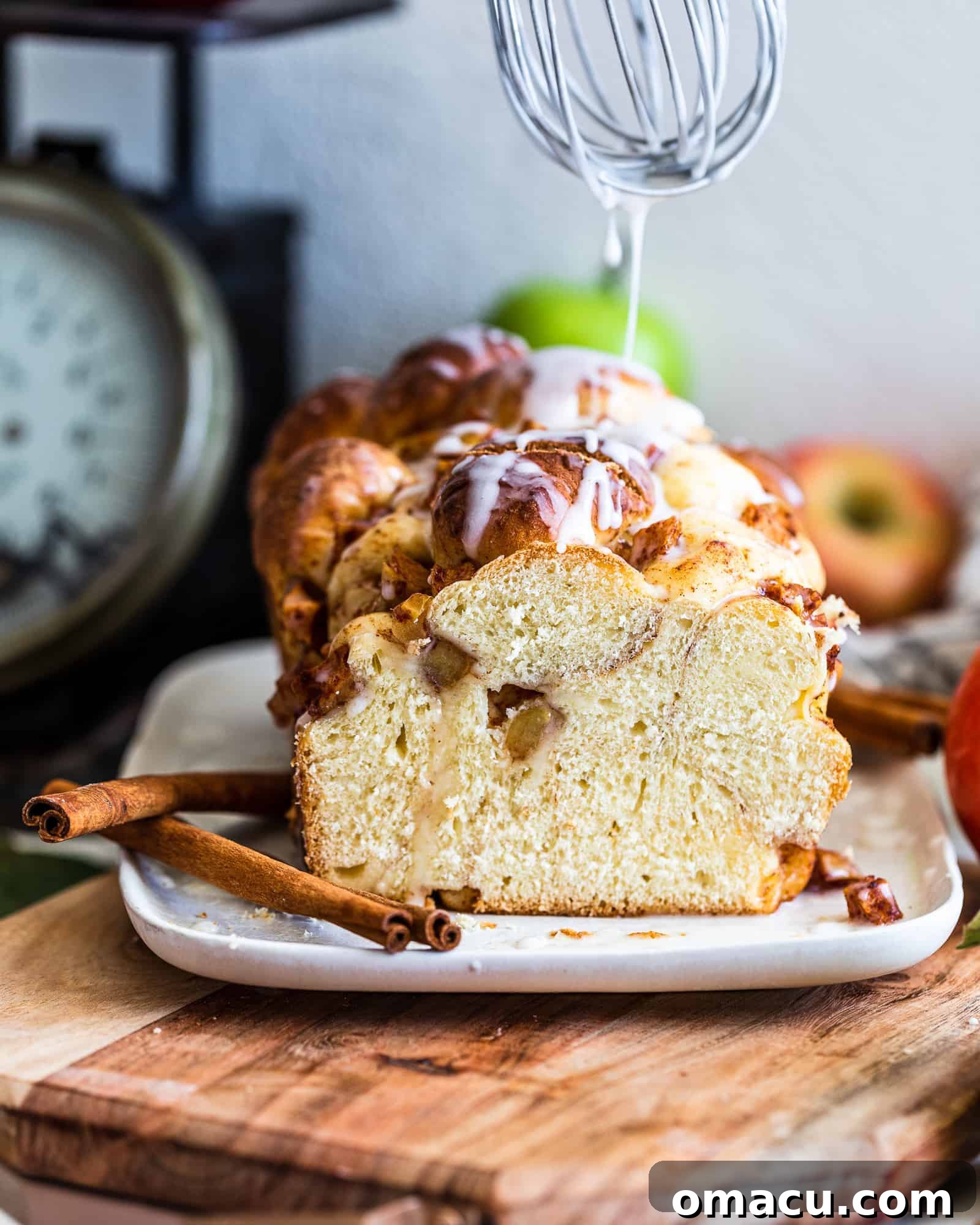 Apple and Pear Bread being drizzled with a sweet apple cider glaze by a whisk