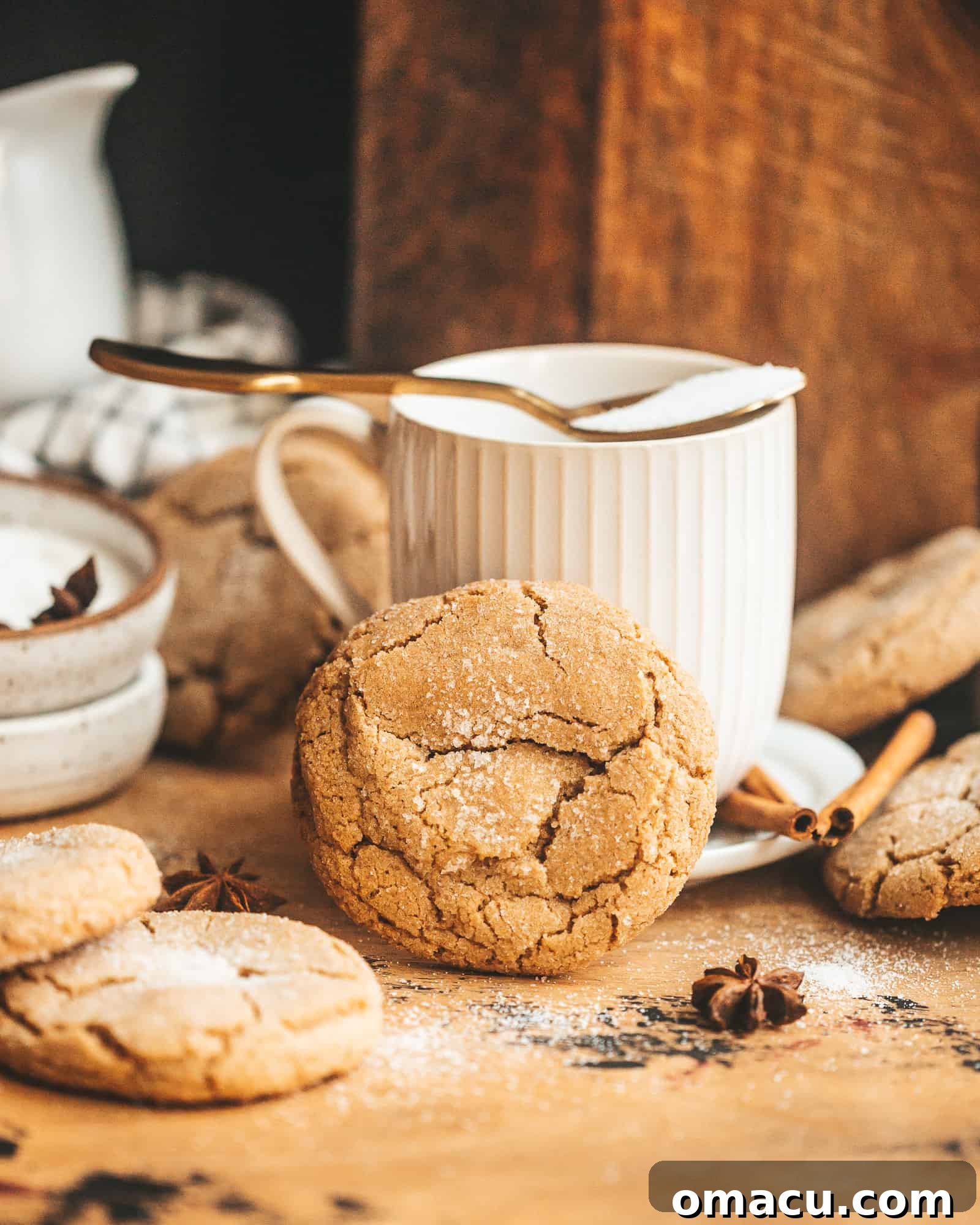 Brown Butter Chai Cookie in front of a tea cup, highlighting its inviting texture