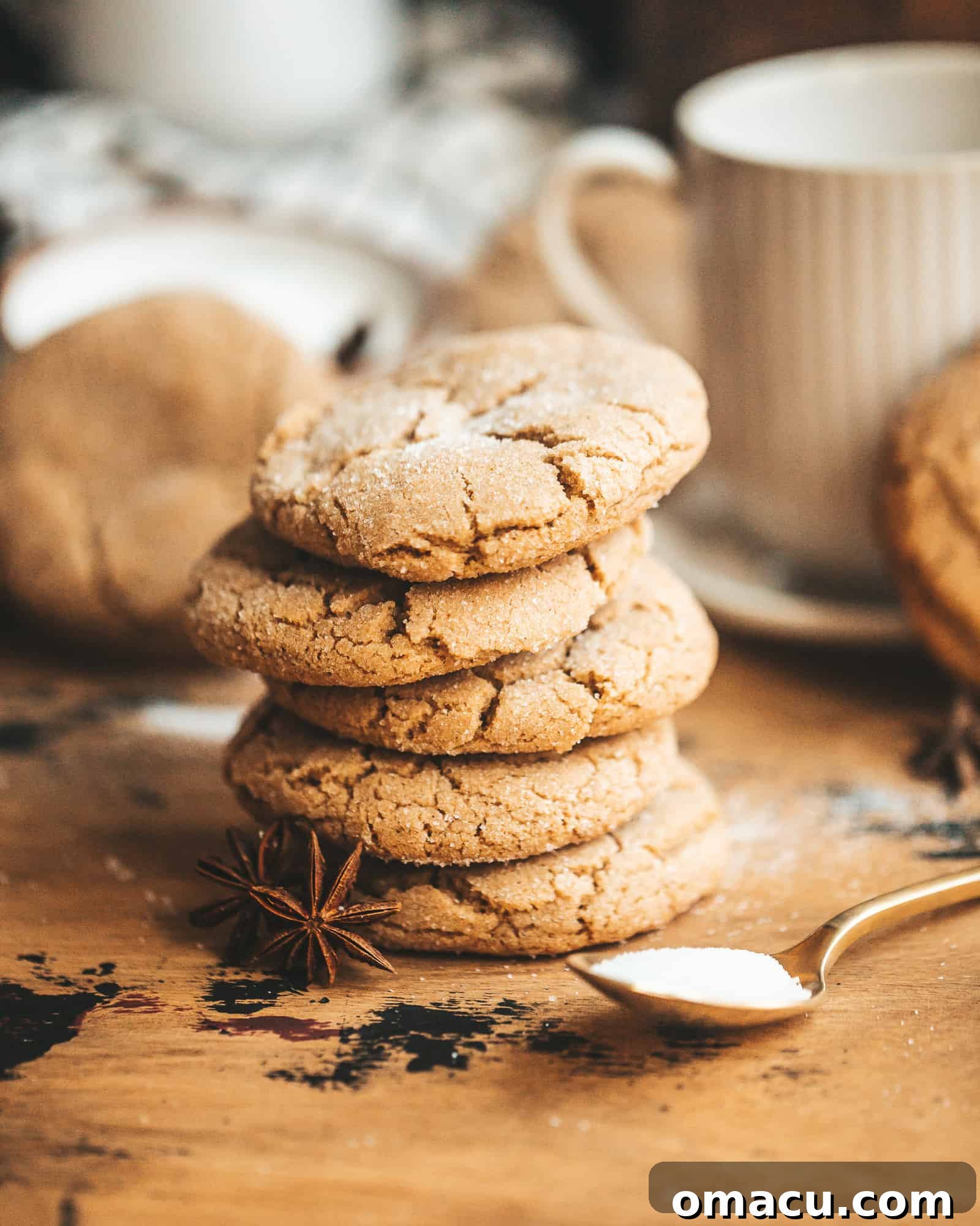 Stacked brown butter chai cookies with a cozy mug in the background, showcasing their golden-brown hue