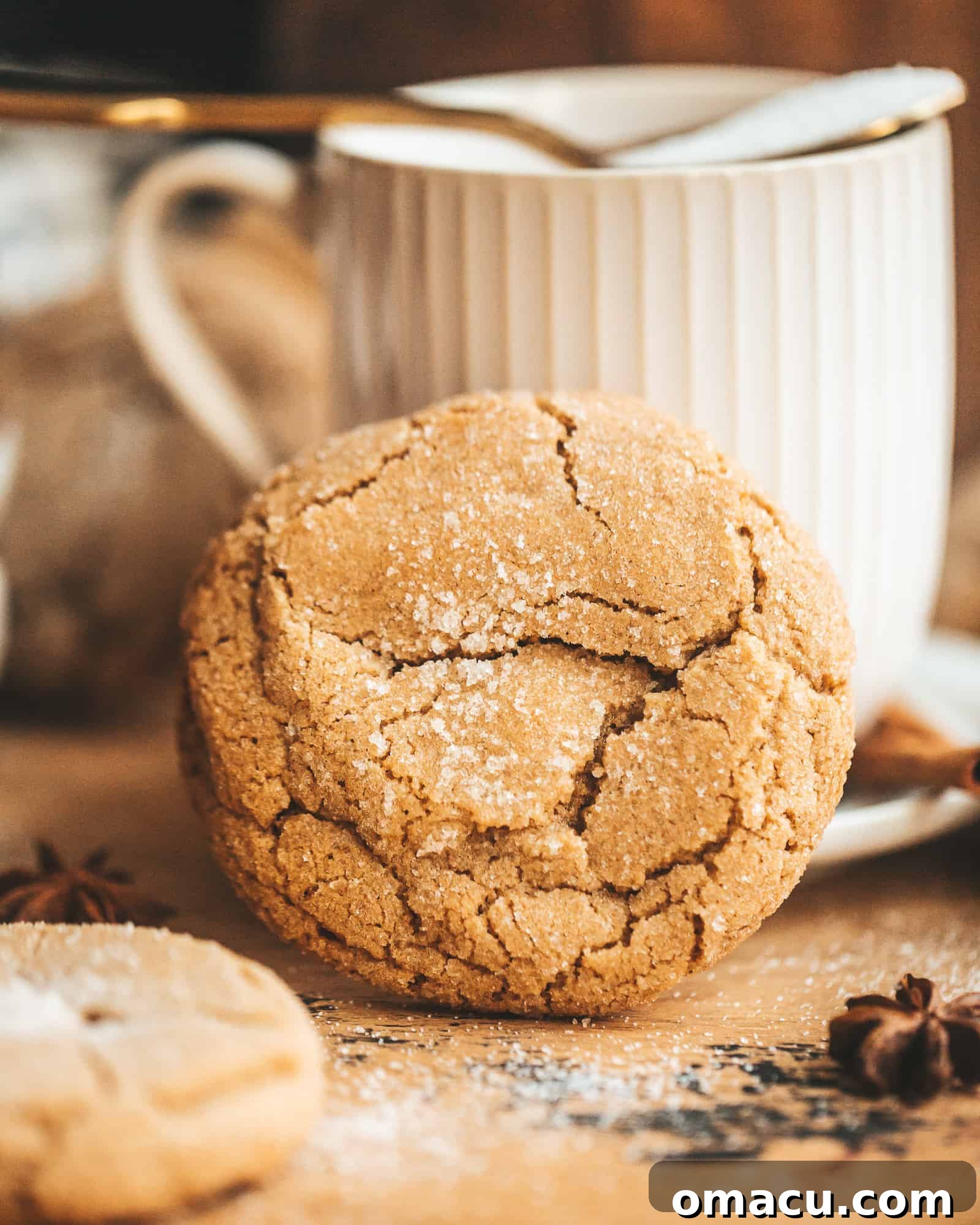 A single brown butter chai cookie positioned artfully in front of a tea cup, ready to be enjoyed