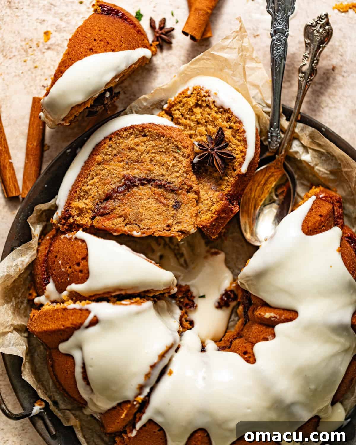 A beautifully frosted sweet potato pound cake with thick cream cheese frosting, elegantly placed on a white serving plate with spoons, ready to be enjoyed.