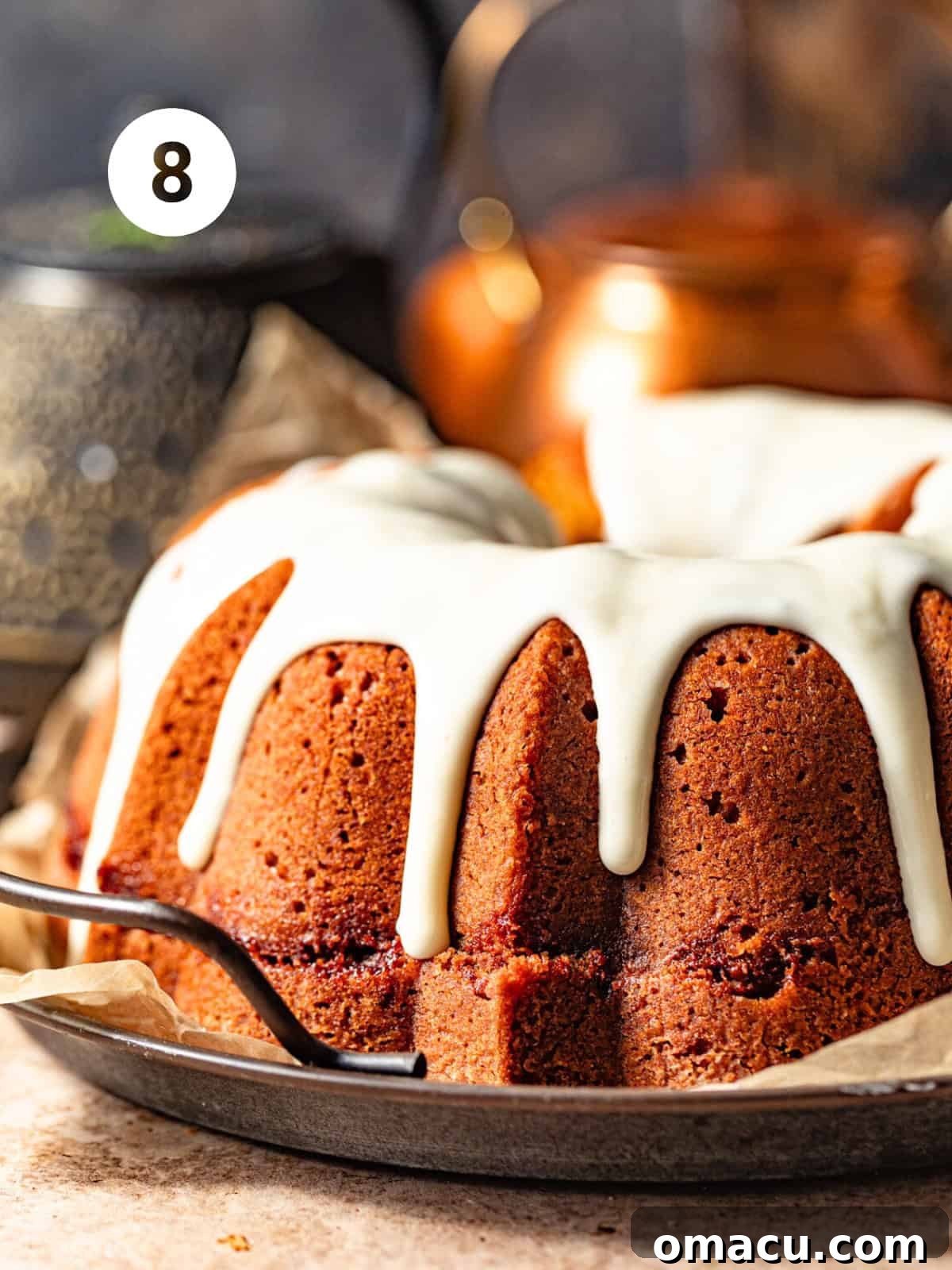 A glorious sweet potato pound cake, elegantly drizzled with a rich cream cheese frosting, presented on a beautiful serving plate, ready to be cut into slices.