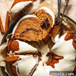 Sweet potato pound cake topped with cream cheese frosting on a serving plate with spoons.
