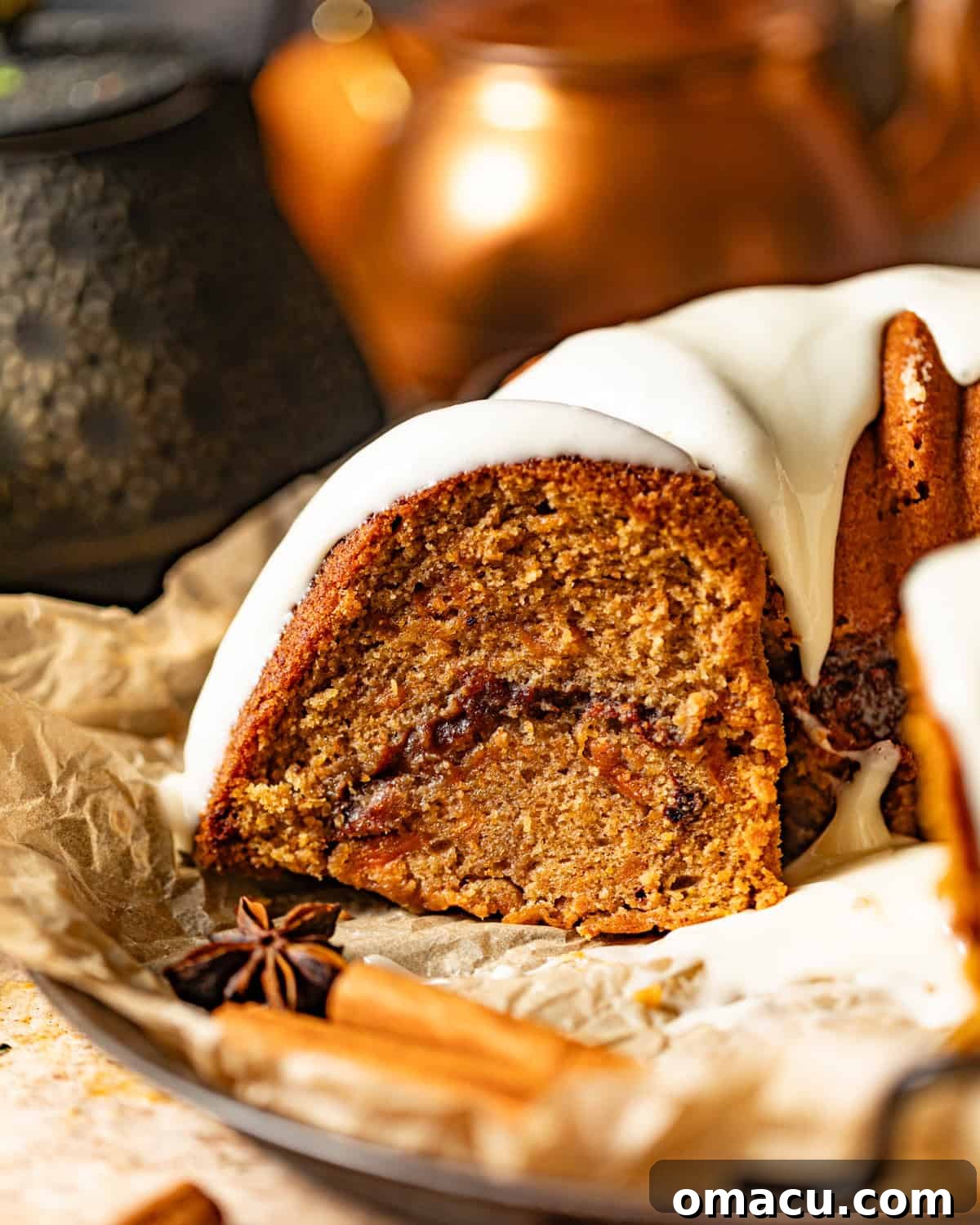 A delectable slice of sweet potato pound cake resting on parchment paper, beautifully garnished with fragrant cinnamon sticks and star anise pods, highlighting its spiced essence.