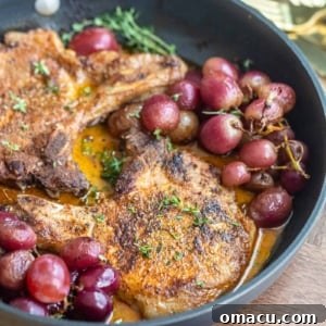Finished plate of Garlic Rosemary Pork Chops with Roasted Grapes, garnished.