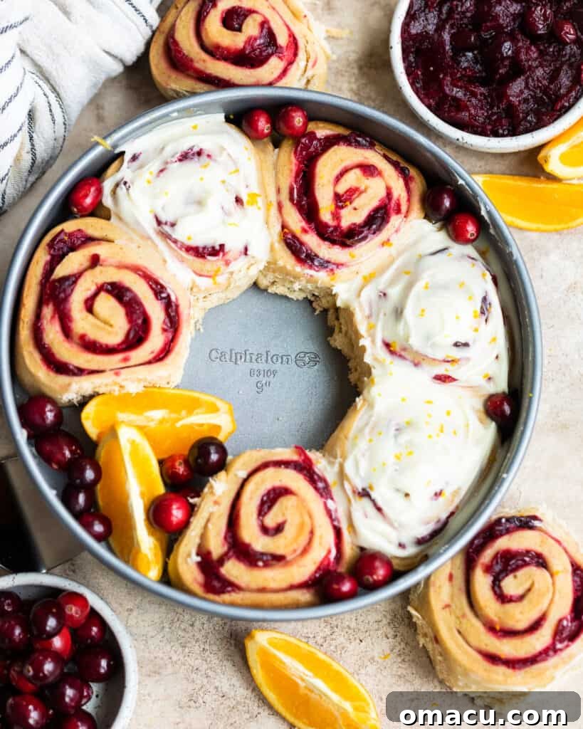 A top-down view of tender Cranberry Cinnamon Rolls, showcasing their beautiful swirl and vibrant cranberry filling.