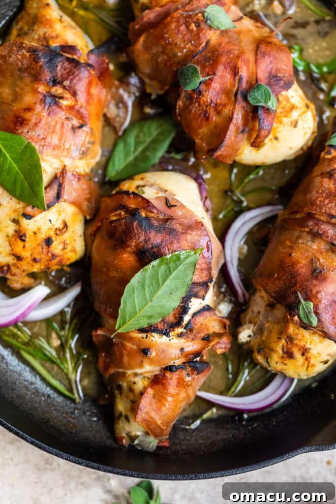 Prosciutto wrapped chicken with fig glaze in a rustic cast iron skillet, ready to serve