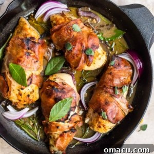 Four pieces of prosciutto wrapped chicken with fig glaze in a cast iron skillet