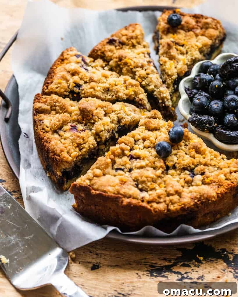 a whole blueberry prune buckle on a circular serving tray