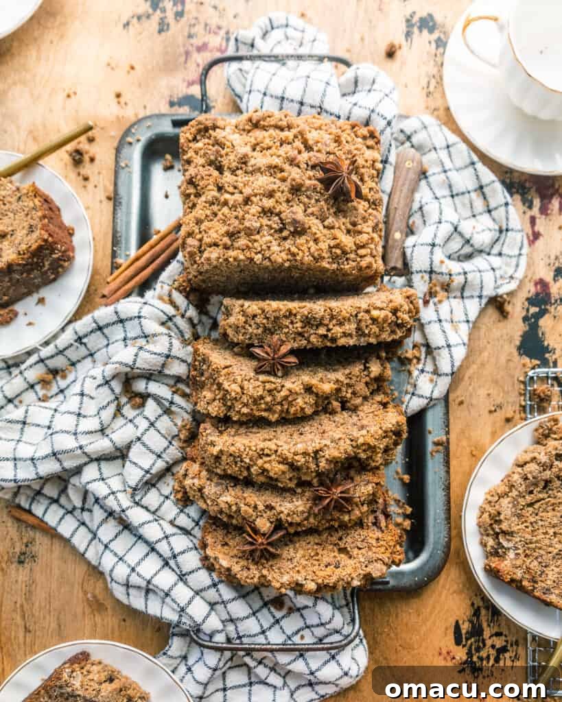 Sliced maple cinnamon banana bread on a rustic serving tray, showcasing its tender crumb and streusel topping
