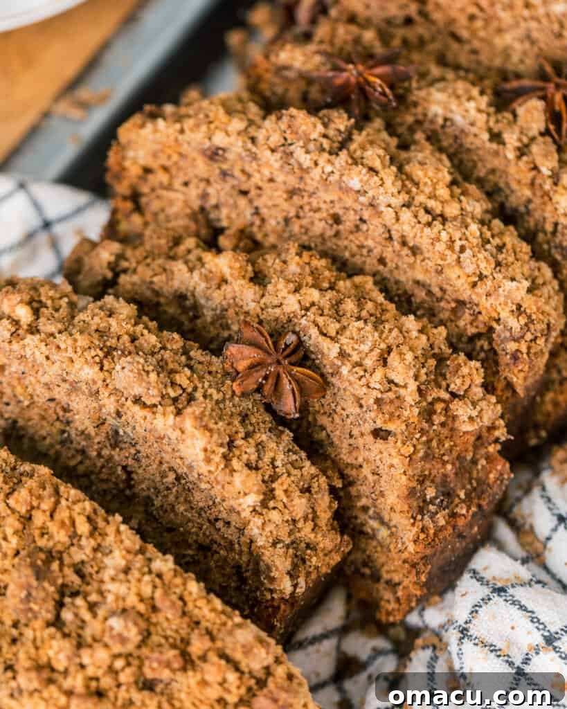 Close-up of a slice of maple cinnamon banana bread resting on a dish cloth, highlighting its moist texture