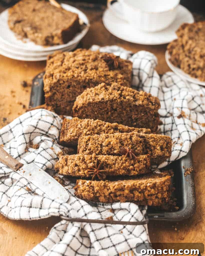 Freshly baked maple cinnamon banana bread, sliced and presented on a serving tray with coffee cups in the background