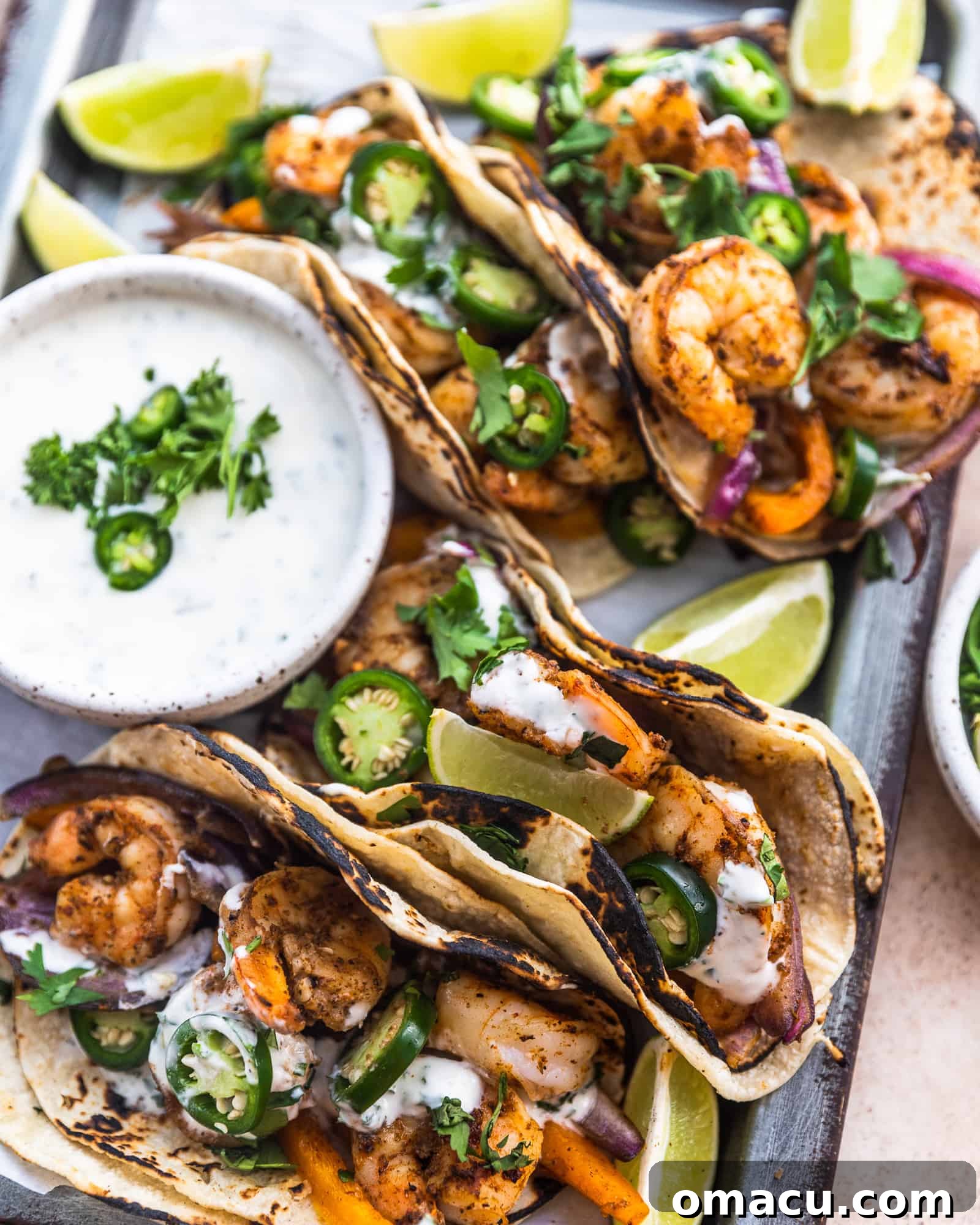 tacos on a serving tray with limes and ranch sauce from an aerial view