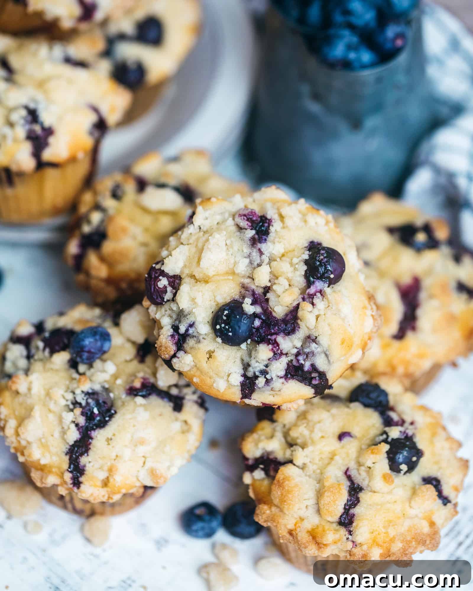 A charming stack of blueberry crumb cake muffins nestled in a bowl, showcasing their golden tops